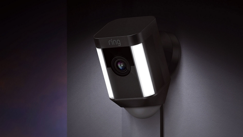 An image of a Ring security camera positioned on the side of a wall, shining down with the camera on.