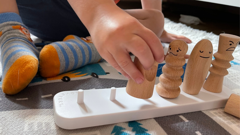 A little boy sits on the floor and plays with toys.