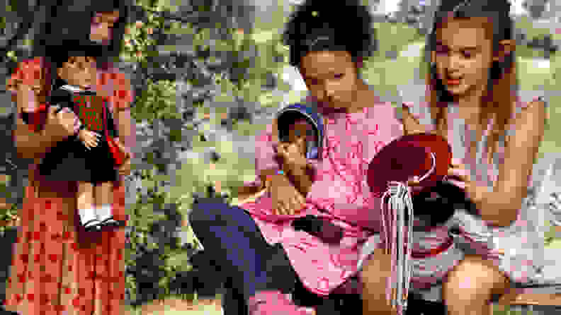 Three young girls each holding a different American Girl doll