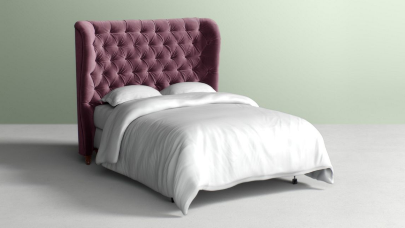 Magenta colored velvet tufted bed frame.