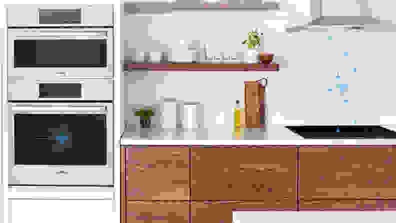 A shot of a kitchen setup with a Bosch oven and stove. There's some very vague symbols superimposed over the image that indicate WiFi connectivity and that the range hood has turned on remotely.