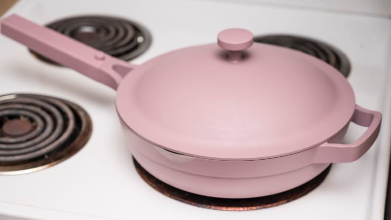 A lavender colored Always pan is on a white stove.