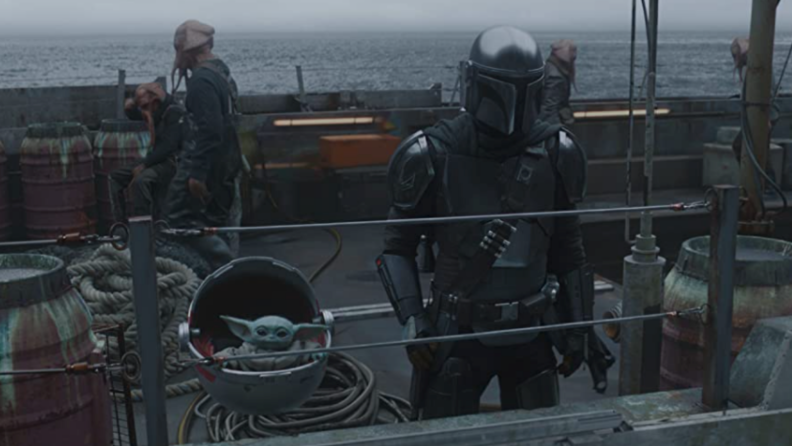 A still from the Mandalorian featuring Mando and Baby Yoda on a ship.