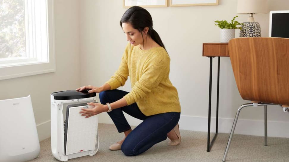 Woman next to Filtrete Smart Air Purifier Console in a home office