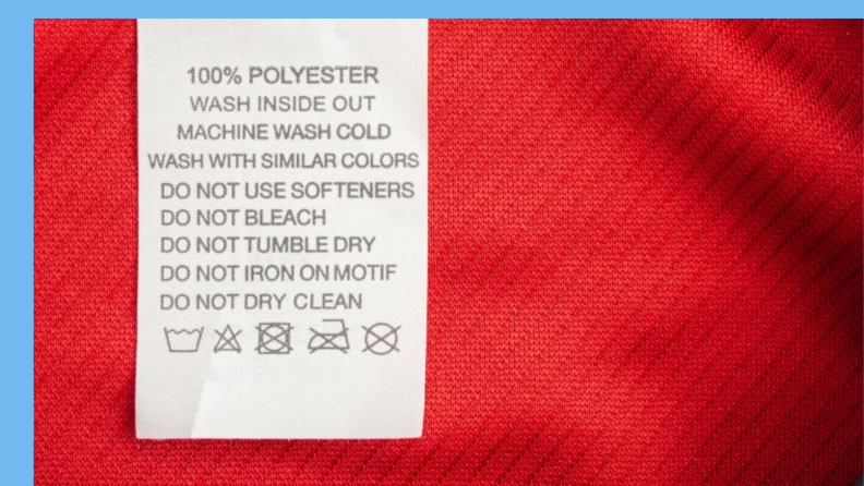 Tag on red shirt with laundry care labels and symbols