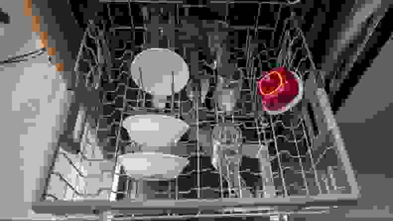 Close up of an upper rack with dishes in a dishwasher.