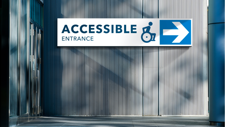 A sign that says, "Accessible entrance" in the color blue with a stick figure in a wheelchair.