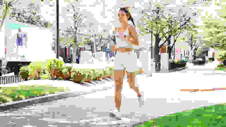 woman running wearing  white activewear