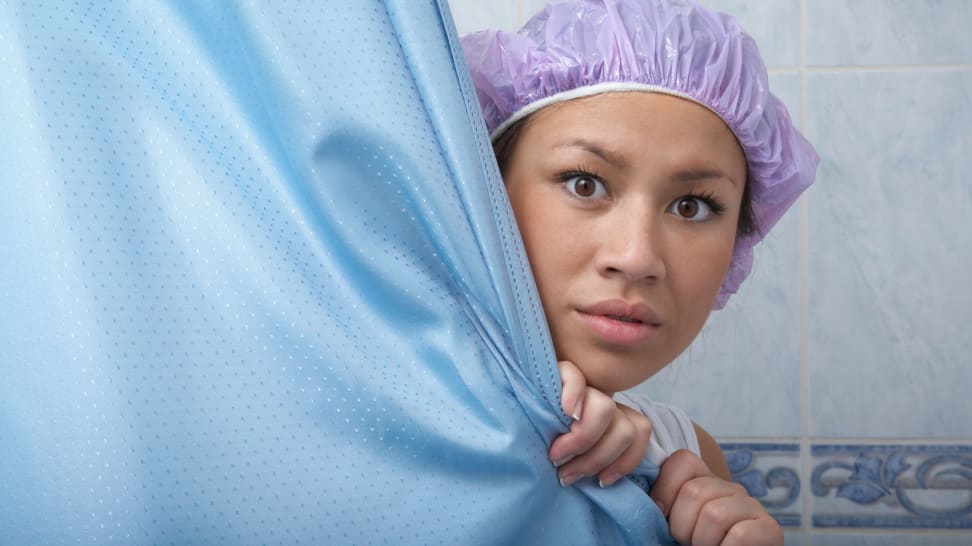 A woman holding her shower curtain