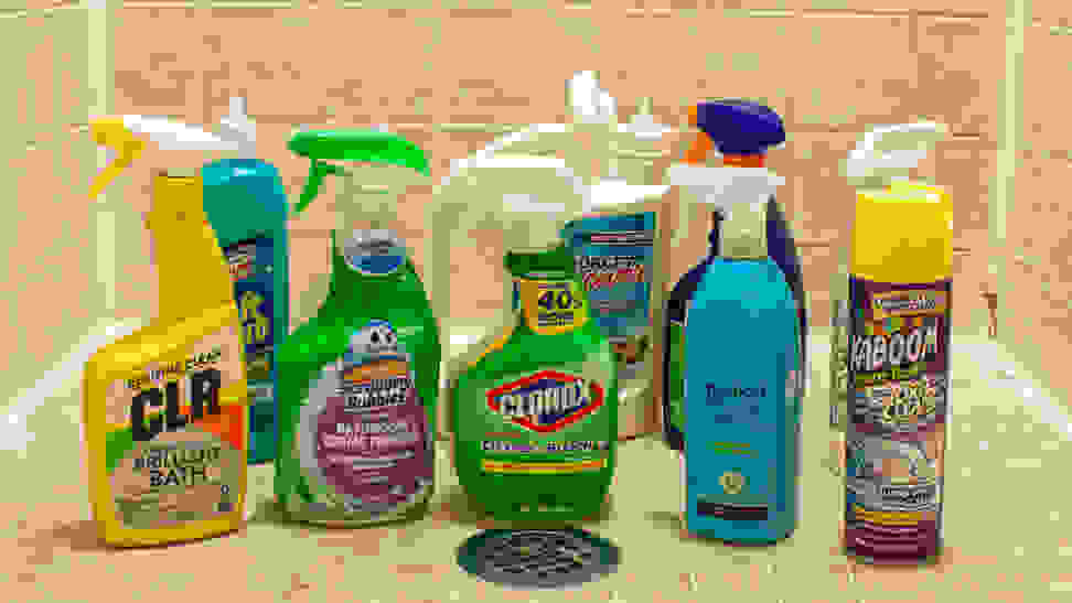 An array of shower cleaners, situated in a small shower around a drain.