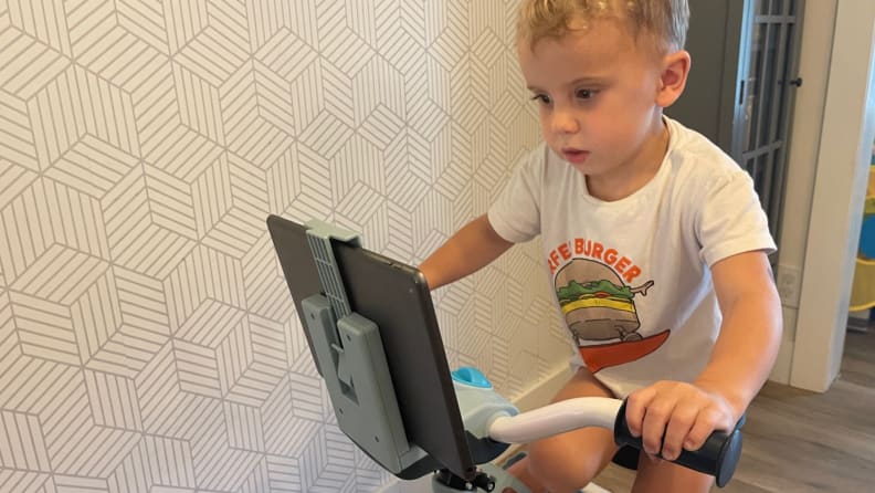 A toddler rides a kid's fitness bike