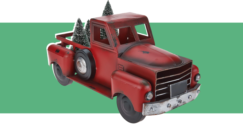 An image of a red model truck with model Christmas trees in the back.