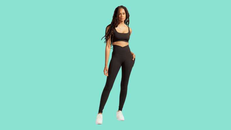 A model wearing a matching black athletic crop and tights set.