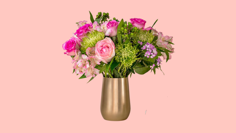 A bouquet of BloomsyBox flowers in a vase on a pink background.