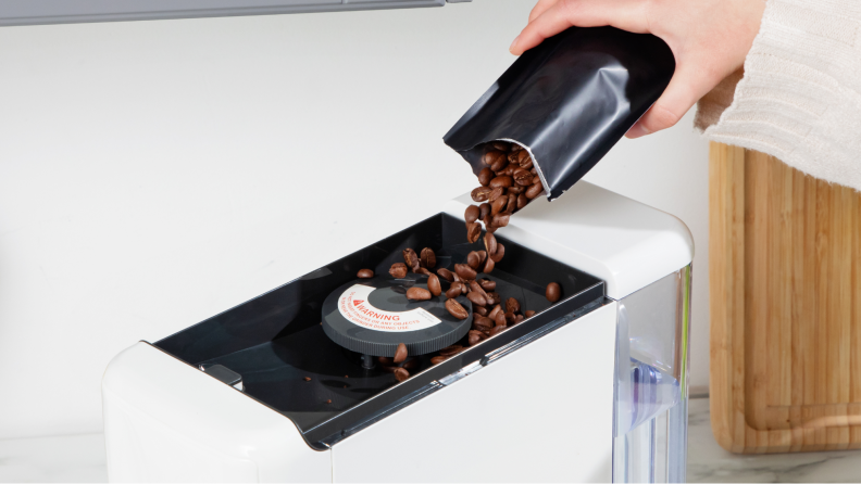Coffee beans being disposed into the coffee maker.
