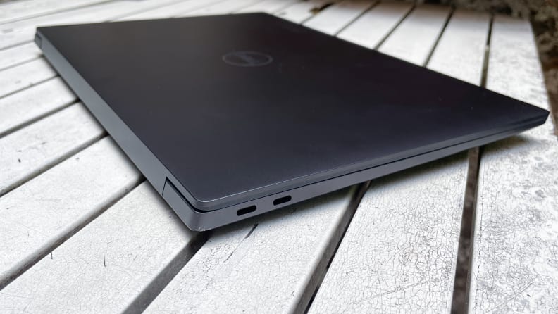 Close-up view of two of the ports on the side Dell XPS 14 laptop on top of table.
