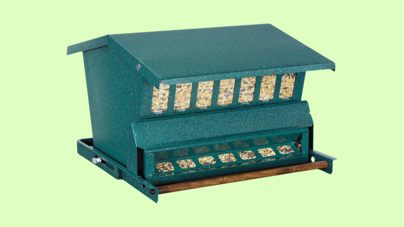 The blue-gray Heritage Farms Woodlink Absolute Squirrel Resistant Bird Feeder on a light green background.