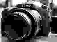 Monochrome close-up of a Lumix superzoom digital camera.