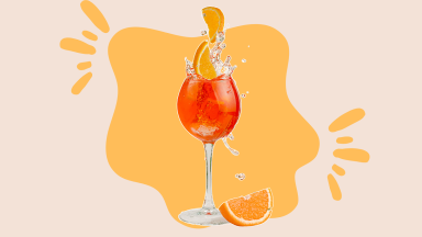 An Aperol Spritz cocktail in front of an orange background.