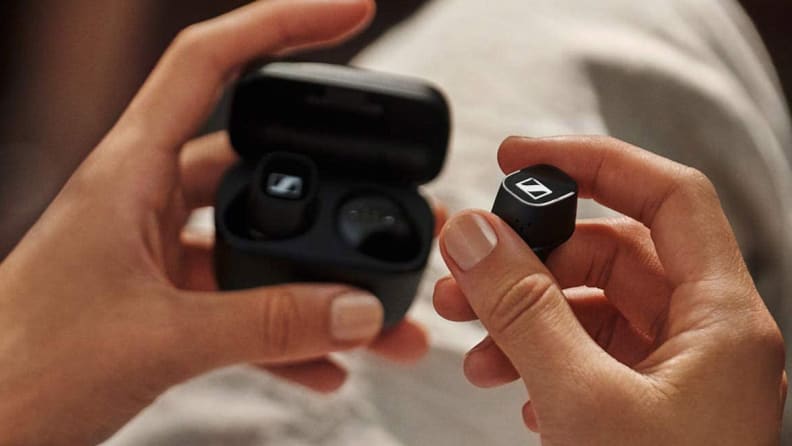 A person takes headphones out of a protective case.