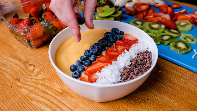 Adding blueberries to smoothie bowl