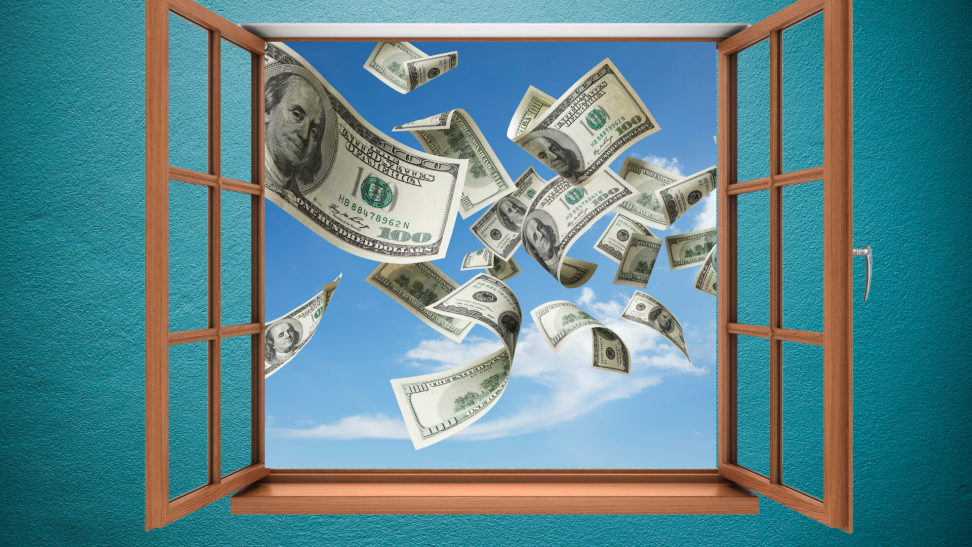 Dollar bills fly out an open window into a blue sky