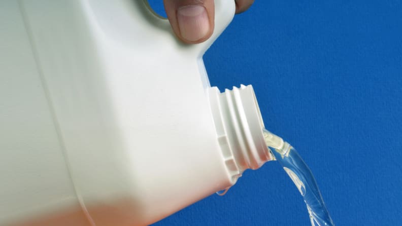 Person pouring chemical in bottle.