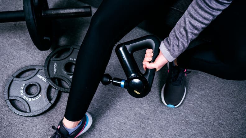 A woman using the Theragun Elite on her calf muscle.