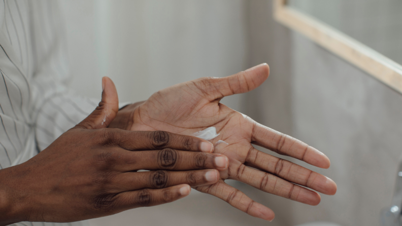 Person rubbing moisturizer into hands.