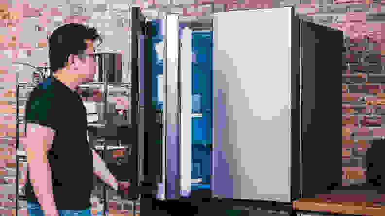 A person opens a refrigerator door