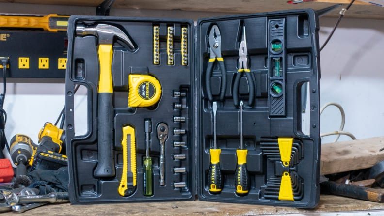 The toolkit stands in the corner of a tool-filled work bench. The kit is splayed open, showcasing all the tools inside the case.