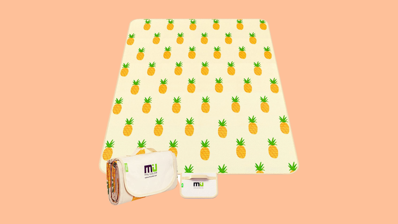 A MiuColor Pineapple Beach Blanket against a peach color background.