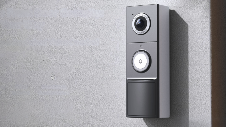 A video doorbell mounted to a wall next to a front door