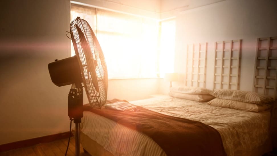 a fan sits in a sunlit bedroom in the summer