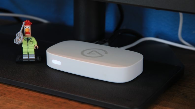 The Elgato Game Capture Neo, a white plastic box on top of a computer.