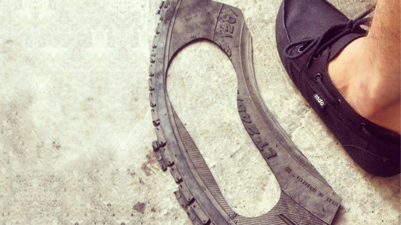 A tire with a cut-out of a footbed for shoes.