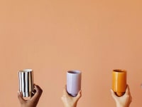 Five hands hold up different colored ceramic cups