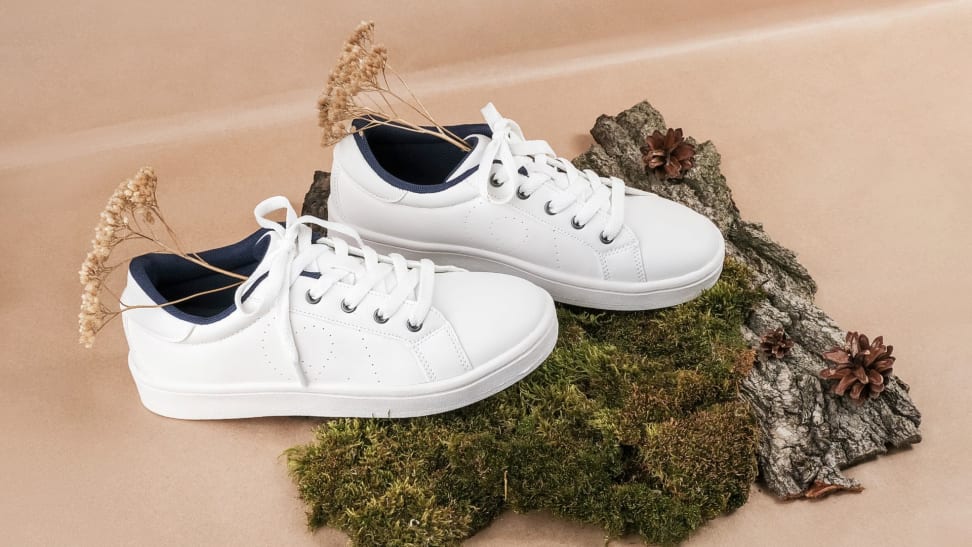 White shoes with plants in them, sitting atop bark
