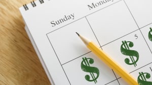 A calendar on a desk labeled with dollar signs on each day