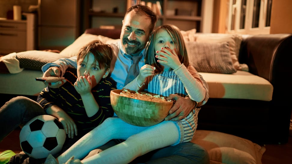 Dad and two kids watching a movie at home