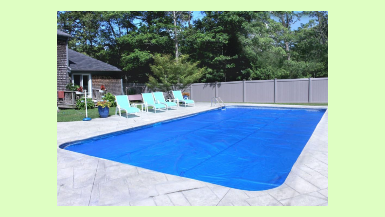 A blue solar pool cover from Robelle covers a swimming pool.