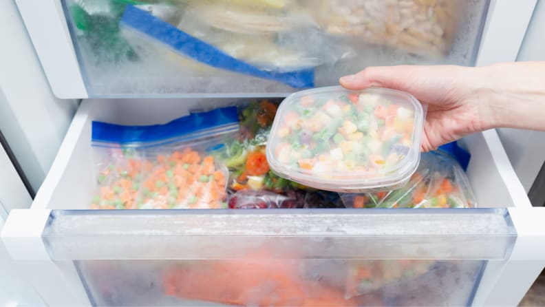 A freezer full of frozen bags and food containers