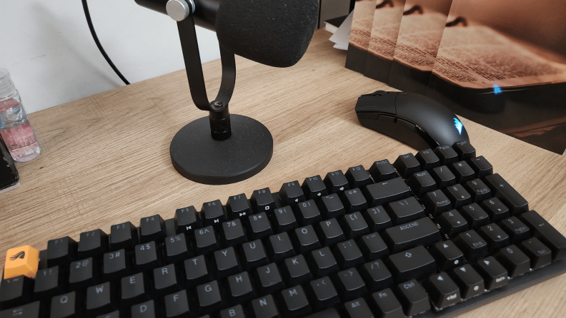 black keyboard with microphone above and mouse next to it on desk