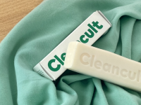 A Cleancult cleaning bar lays on a green towel.