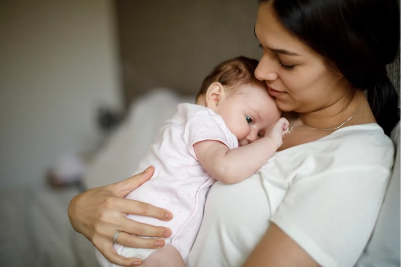 Mother holds and comforts her infant baby