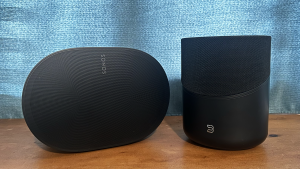 The Sonos Era 300 and the Bluesound Pulse M home audio ecosystems placed side by side on a wooden surface.