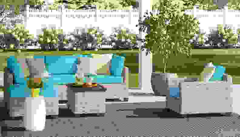 Patio furniture with aqua blue seating against blooming background