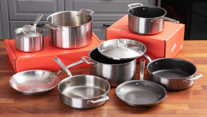 An array of nonstick and stainless steel pots and pans on a wooden surface