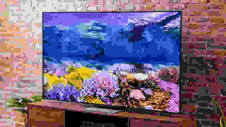 TCL 75R655 with underwater display in front of brick wall indoors.