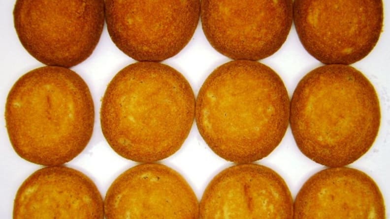 The underside of twelve sugar cookies arranged in three straight rows.